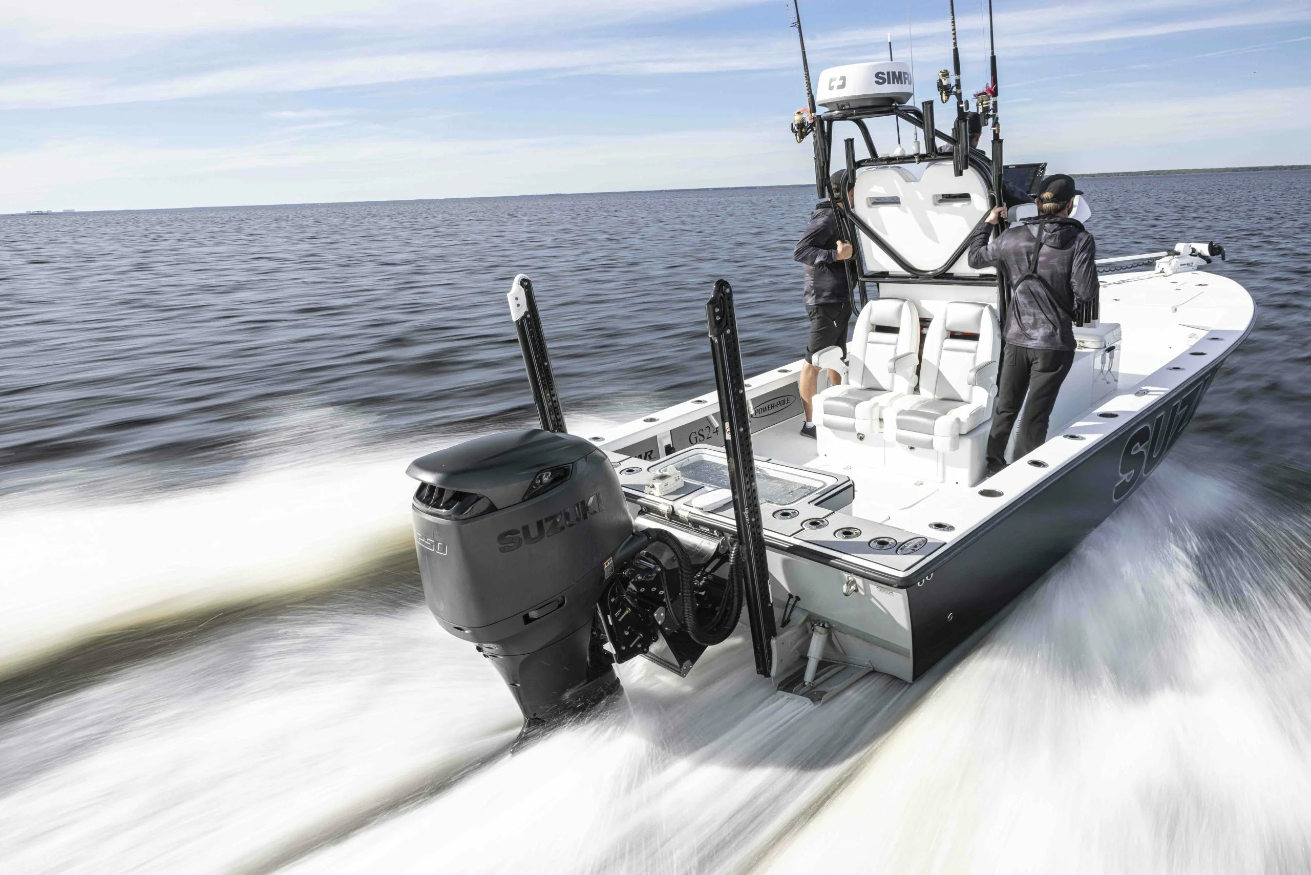 Speedboat cruising on open water with two individuals onboard.